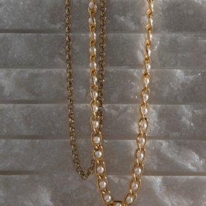 Golden Chain and Pearl Necklace on Stone Background